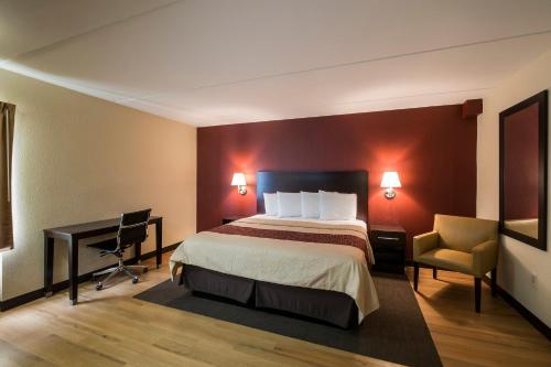 休斯顿休斯顿红屋顶客栈 - 能量大道的配有一张床和一张书桌的酒店客房