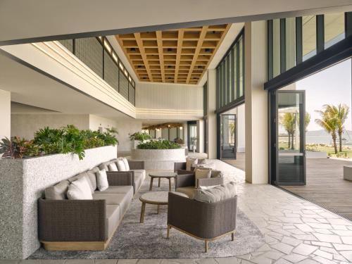 汤斯维尔Ardo的开放式大堂配有沙发、椅子和植物