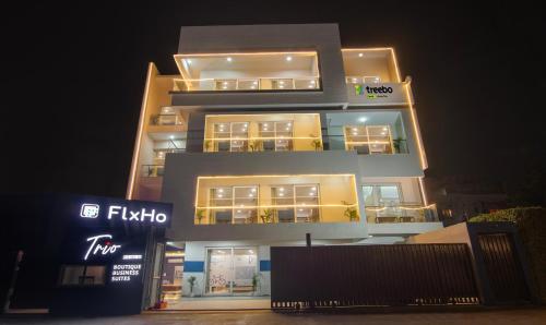 古尔冈Treebo Trend FlxHo Trio - Medanta Medicity Gurgaon的一座高大的建筑,灯火照亮
