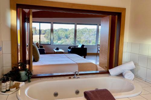 玛格丽特河山顶公寓酒店的一间卧室配有一张床和一个浴缸。