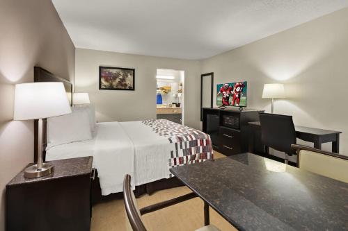 凯夫城洞穴城红屋顶套房酒店的小酒店客房配有一张床和一张书桌