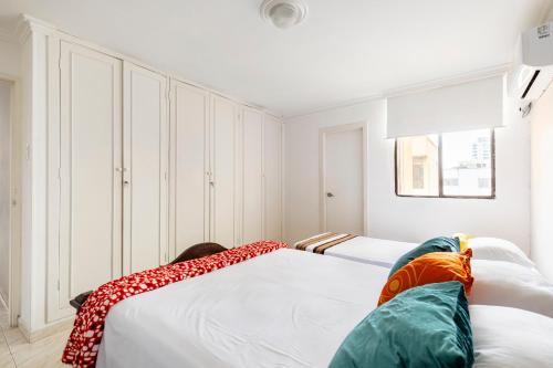 巴兰基亚Hermoso Apartamento Riomar的一间白色卧室,配有两张床和窗户