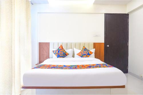 浦那FabHotel Majestic Luxurious的一间卧室配有一张带色彩缤纷枕头的大床