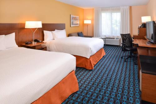 奥兰多奥兰多机场费尔菲尔德客栈的酒店客房配有两张床和一张书桌