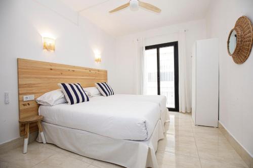 罗列特海岸Hotel Casa Mas的白色卧室配有带条纹枕头的白色大床