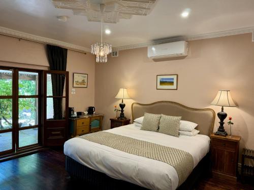 塔南达Jacobs Creek Retreat - Barossa Valley的一间卧室配有一张大床和一个吊灯。