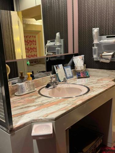 神户STYLISH的浴室的柜台设有水槽和镜子