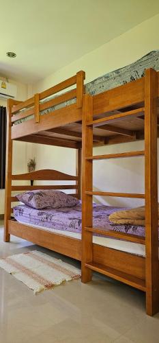 Ban Nua KhlongPakin house的配有紫色床单的客房内的两张双层床
