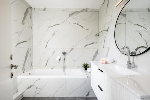 内坦亚Poleg Serenity Villa by Sea N' Rent的白色的浴室设有浴缸和镜子