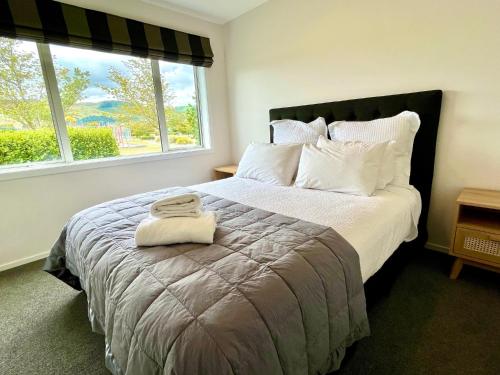 KinlochLarge and Luxurious at the Lake的一间卧室配有一张大床和两条毛巾