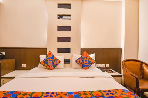 兰奇FabHotel Emerald的一间卧室配有带色彩缤纷枕头的床。