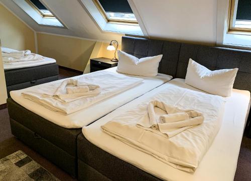 莱比锡克劳塞维茨卡尔酒店的客房内的两张床和毛巾