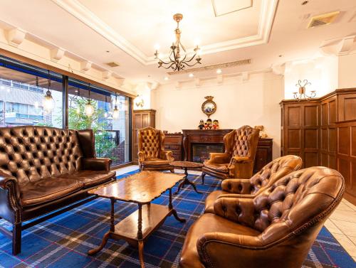 神户神户山乐TOR ROAD 酒店的客厅配有皮革家具和桌子