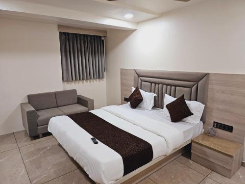 艾哈迈达巴德HOTEL R K VILLA的一间卧室配有一张大床和一张沙发