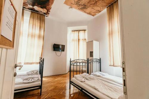 萨拉热窝法兰兹费迪南旅馆的一间卧室设有两张床和两个窗户。