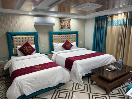 伊斯兰堡Ambassador Homes的酒店客房设有两张床和一张桌子。
