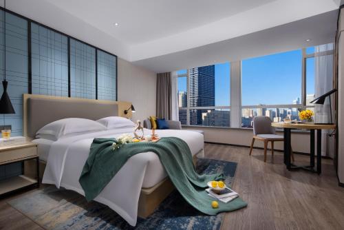 广州宜尚酒店(广州北京路步行街天字码头店)的一间卧室配有一张大床,上面有绿毯