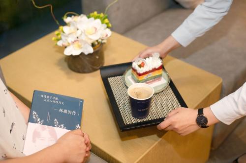 深圳漫时酒店(深圳大学科技园店)的一张桌子,上面放着一盘蛋糕和一杯咖啡