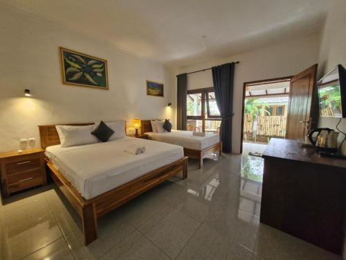PawenangBale Kebon Rangsot的酒店客房设有两张床和电视。