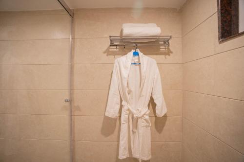 穆索里Super Hotel by Perfectstayz Mall Road的浴室的衣架上挂着白色的长袍