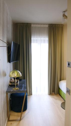 布雷西亚Hotel Battisti 31的酒店客房配有一张床和一张带台灯的桌子