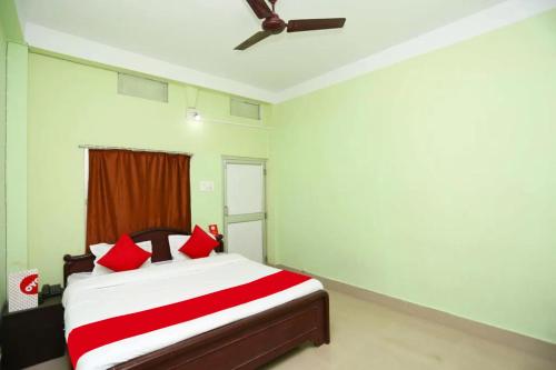 普里Goroomgo Somnath Puri的一间卧室配有红色枕头的床