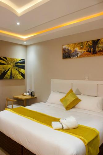 卢萨卡Milestone Hotels的一间卧室配有一张大床和两条毛巾