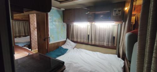 阿德耶Van with 3 double bed, nice and quite place, to 500m beatufill beach的小房间设有一张床和一张书桌,房间设有一张床铺。