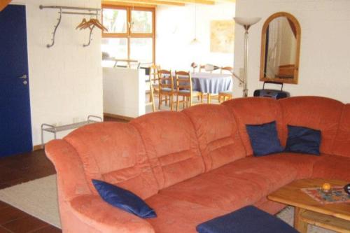 博尔库姆Deetje的客厅里配有带蓝色枕头的橙色沙发