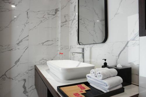 坎古ValStar Hotel Canggu的浴室设有白色水槽和镜子