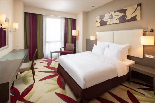 克卢日-纳波卡金色郁金香安娜圆顶酒店的配有一张床和一张书桌的酒店客房
