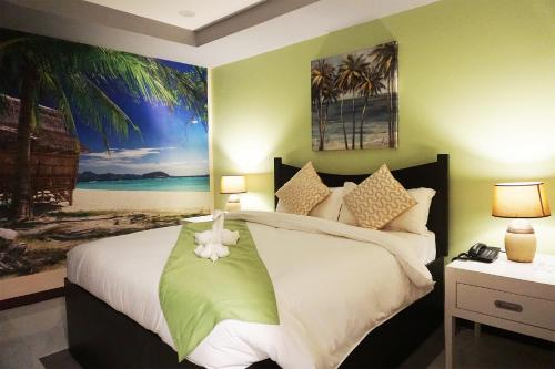 马尼拉AMORE HOTEL MANILA的卧室配有一张床,墙上挂有绘画作品