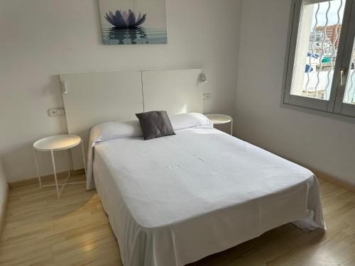 罗萨斯Agi Cap Llarg的卧室配有一张白色的床和黑色枕头