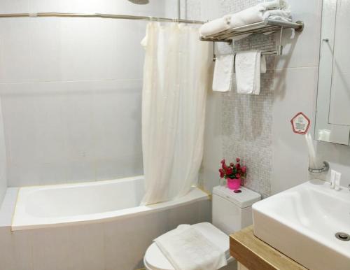 马尼拉AMORE HOTEL MANILA的浴室配有卫生间、盥洗盆和浴缸。