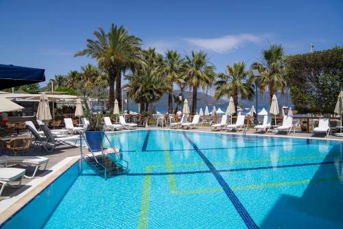 马尔马里斯塞提雅海滩度假酒店的一个带椅子和棕榈树的大型游泳池