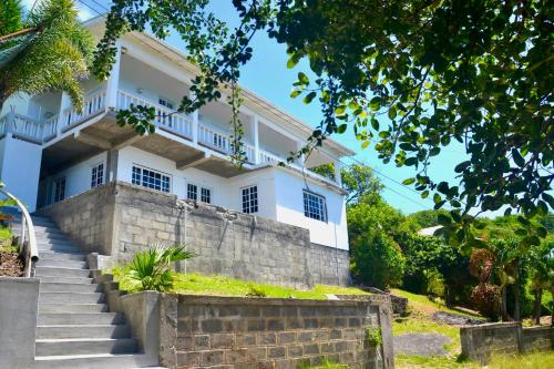 UnionStunning Villa overlooking Friendship Bay Beach的前面有楼梯的白色房子