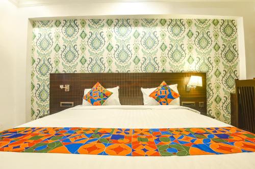 GoaFabHotel Don Hill Beach Resort的一间卧室配有一张大床和色彩缤纷的被子