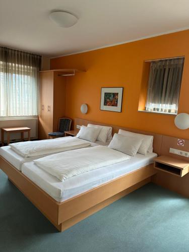 格雷文Hotel-Restaurant Schraeder的卧室设有一张大床,拥有橙色的墙壁