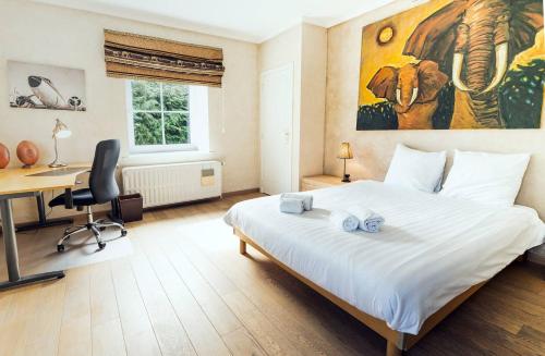 滑铁卢Waterloo Garden residence的一间卧室配有一张带书桌和绘画的床。