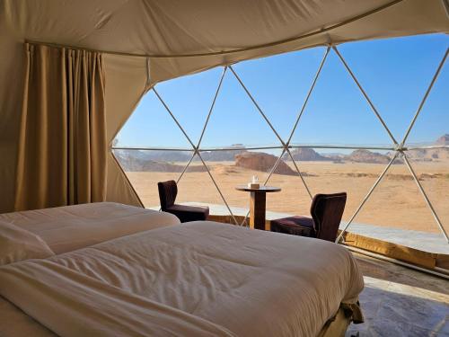 瓦迪拉姆Sama Rum Camp的一间带沙发床的卧室,享有沙漠美景