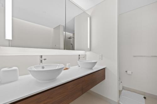 迪拜Brand New Spacious 2 Beds City Walk B9的白色的浴室设有两个盥洗盆和镜子