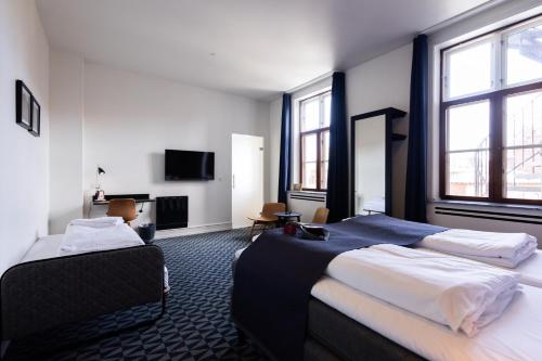 奥胡斯Milling Hotel Ritz Aarhus City的酒店客房设有两张床和电视。
