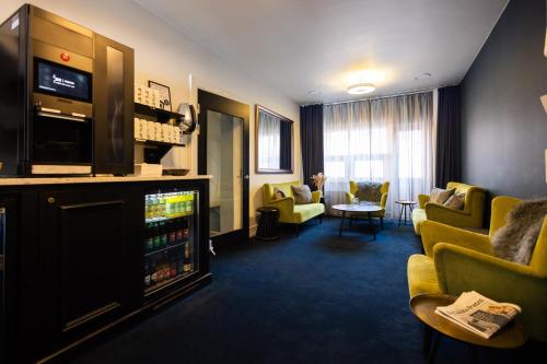 奥胡斯Milling Hotel Ritz Aarhus City的酒店客房设有一个带沙发和电视的等候区。