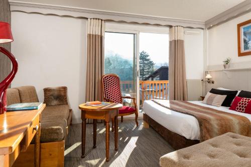 克洛茨巴塔维勒酒店及Spa的酒店客房配有床、沙发和桌子。