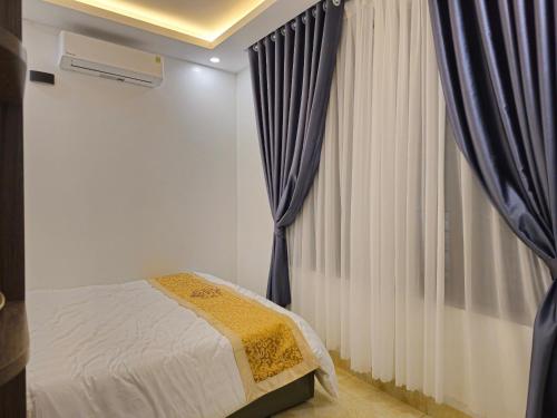 Làng Trang4L HOTEL KIM BÔI的一间卧室配有床和带窗帘的窗户