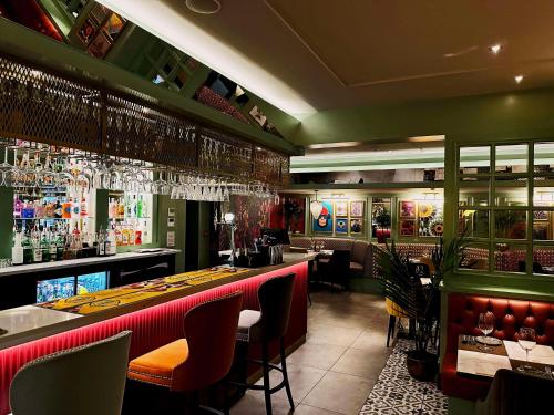 泰恩河畔纽卡斯尔贝斯特韦斯特新肯特酒店的餐厅设有酒吧,拥有红色和绿色的墙壁