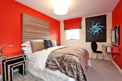 阿伯丁Trendy apartment a short drive from Aberdeen City的一间卧室设有红色的墙壁、一张床和电视