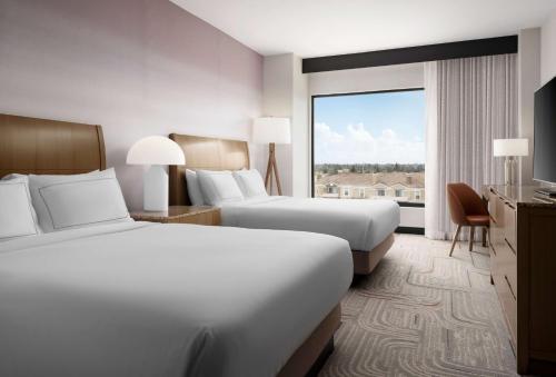 尔湾欧文斯北克特姆逸林酒店的酒店客房设有两张床和大窗户。