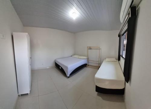 博尼图Recanto das Araras, Transcendental的小房间设有两张床和一台冰箱