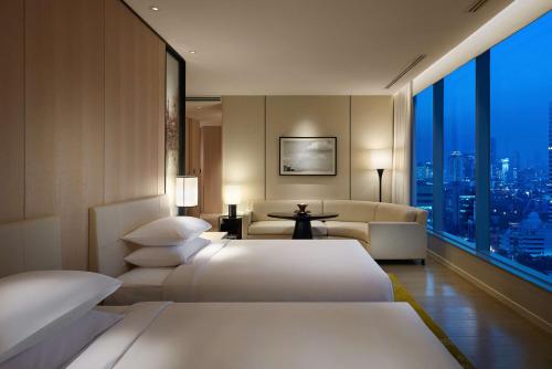 曼谷Park Hyatt Bangkok的酒店客房,设有两张床和一张沙发